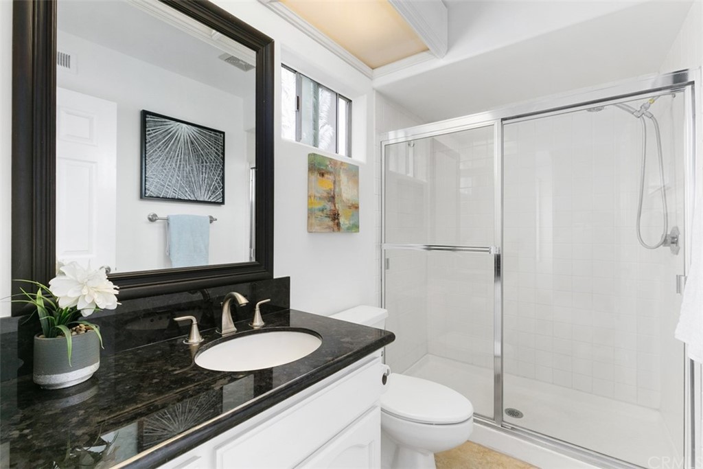 6051 Shadowbrook Circle Huntington Beach, CA 92648 - Photo 32 of 42 a bathroom with a granite countertop sink toilet and shower
