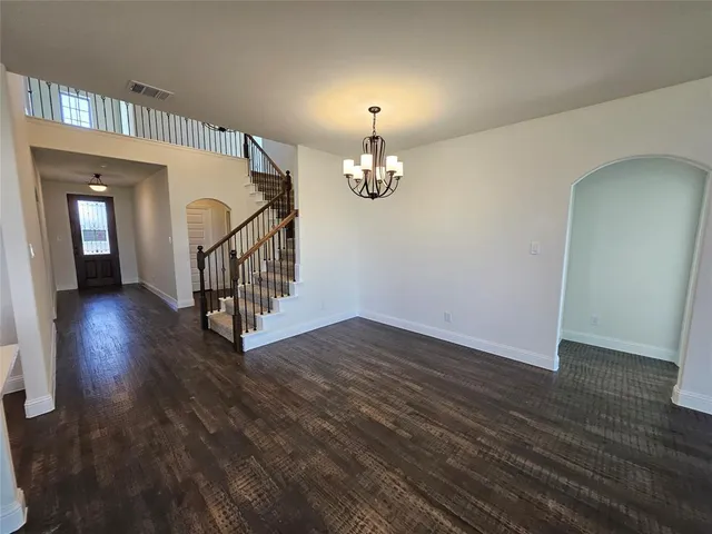 a view of a livingroom with wooden floor and a chandelier