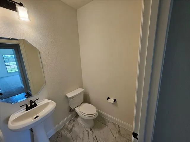 a bathroom with a toilet a sink and mirror