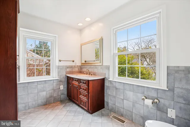 a bathroom with a tub sink and large mirror