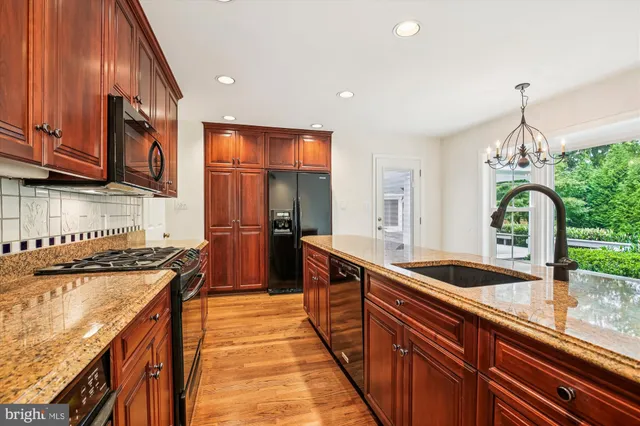 a kitchen with stainless steel appliances granite countertop a sink a stove and a refrigerator