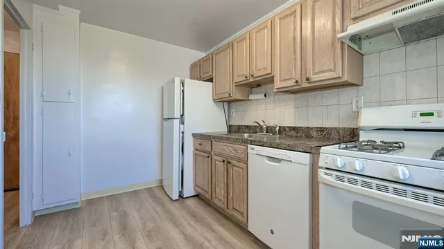 a kitchen with white cabinets white stainless steel appliances and sink