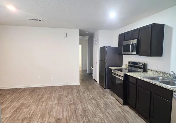 a kitchen with a refrigerator and a stove top oven
