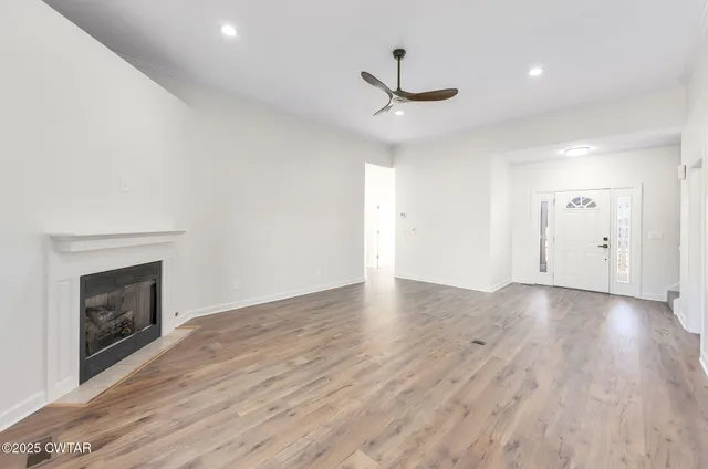 a view of empty room with wooden floor and fireplace