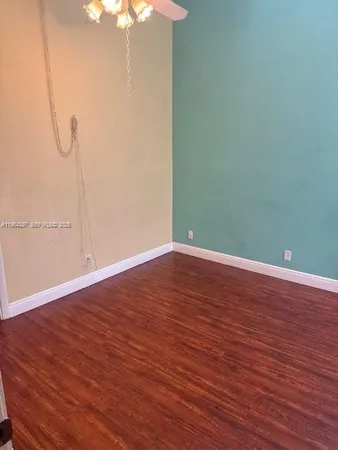 a view of a room with wooden floor and fan