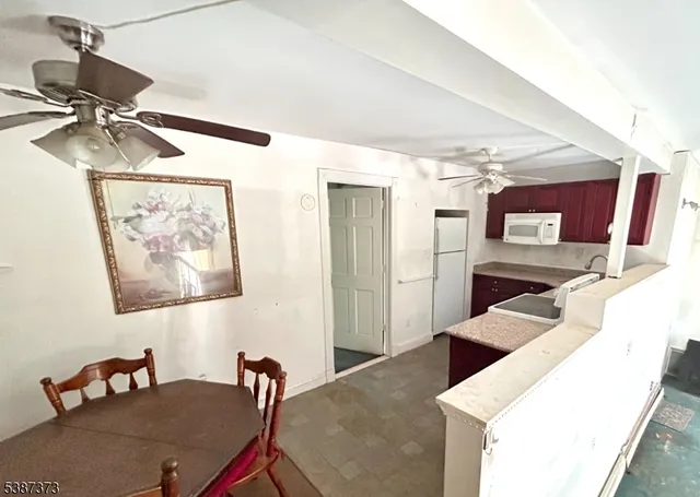 a kitchen with stainless steel appliances kitchen island granite countertop a sink and a refrigerator