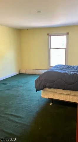 a bed sitting in a bedroom next to a window