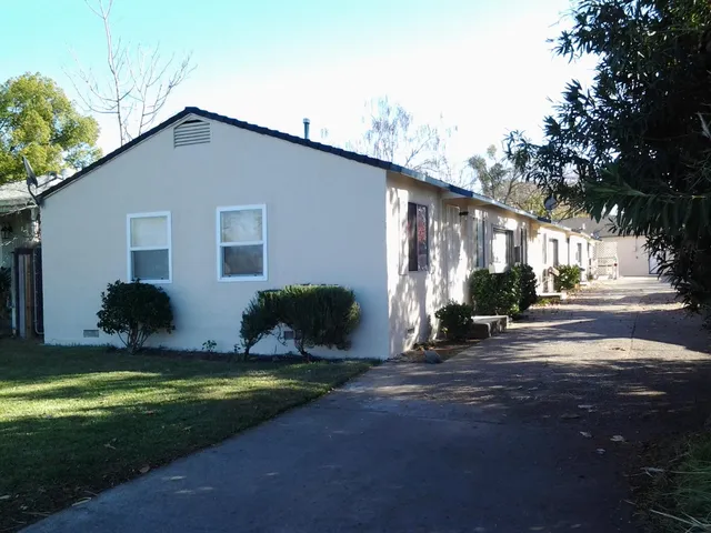 a view of a house with backyard and sitting area