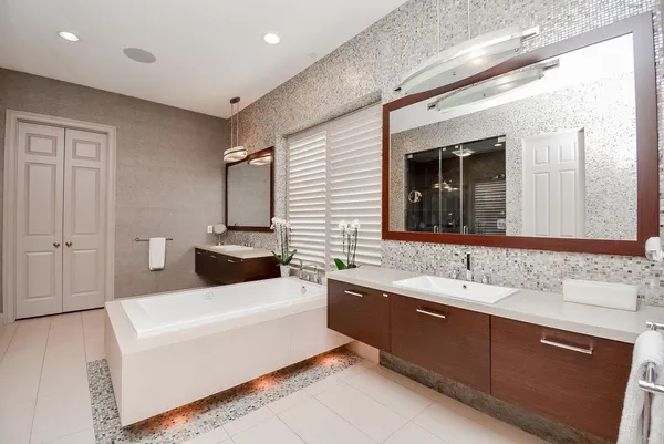 a bathroom with a bathtub a double vanity sink and mirror