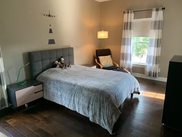 a bedroom with a bed lamp and a window
