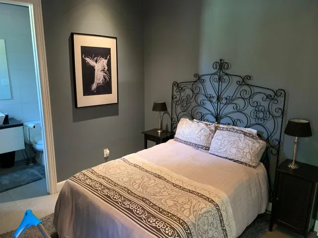 a bedroom with a bed and painting on the wall