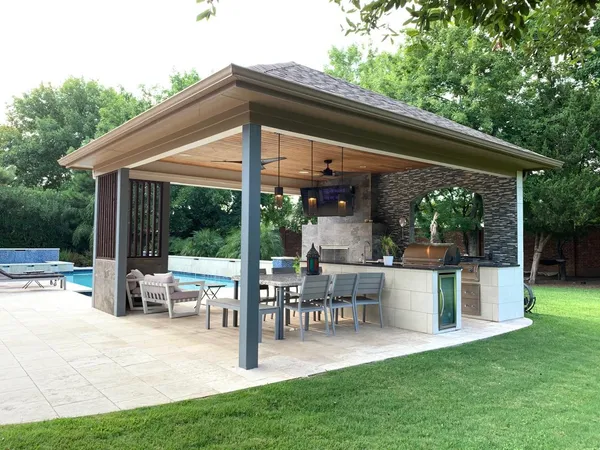 a view of a patio with table and chairs potted plants and floor to ceiling window