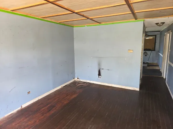a view of a big room with wooden floor and windows
