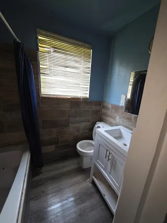 a bathroom with a granite countertop toilet a sink a vanity and mirror