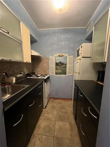 a kitchen with granite countertop a stove sink and cabinets