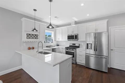 a kitchen that has a lot of cabinets and wooden floor