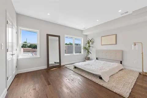 a bedroom with a bed and wooden floor