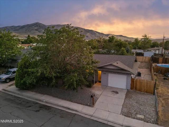 a aerial view of a house with a yard and mountain view in back