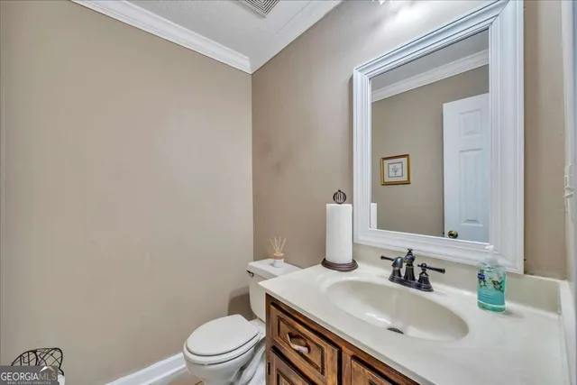 a bathroom with a granite countertop sink a toilet and a mirror