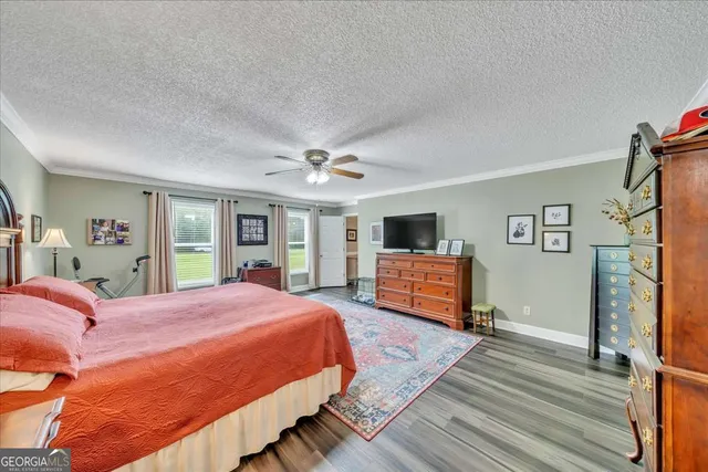 a bedroom with a large bed and a flat tv screen