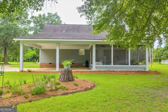 a view of a house with a yard and sitting area