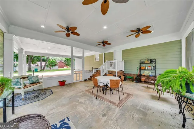 a living room with patio furniture and a potted plant