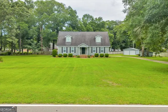 an aerial view of residential houses with outdoor space and trees