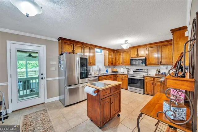 a kitchen with stainless steel appliances granite countertop a refrigerator a stove top oven a sink and dishwasher