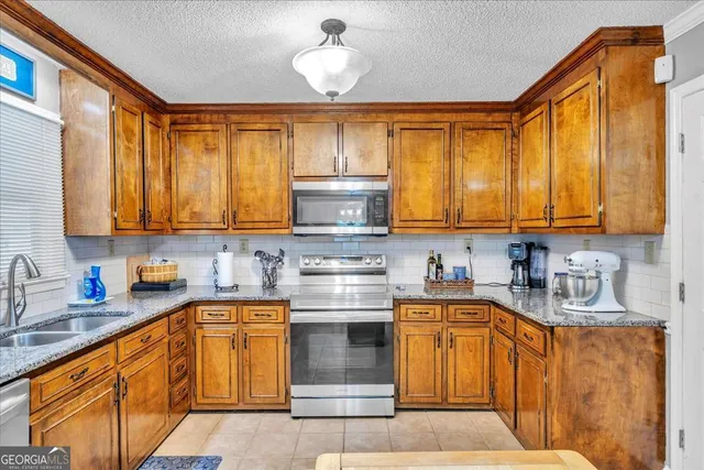 a kitchen with stainless steel appliances granite countertop a stove sink and cabinets