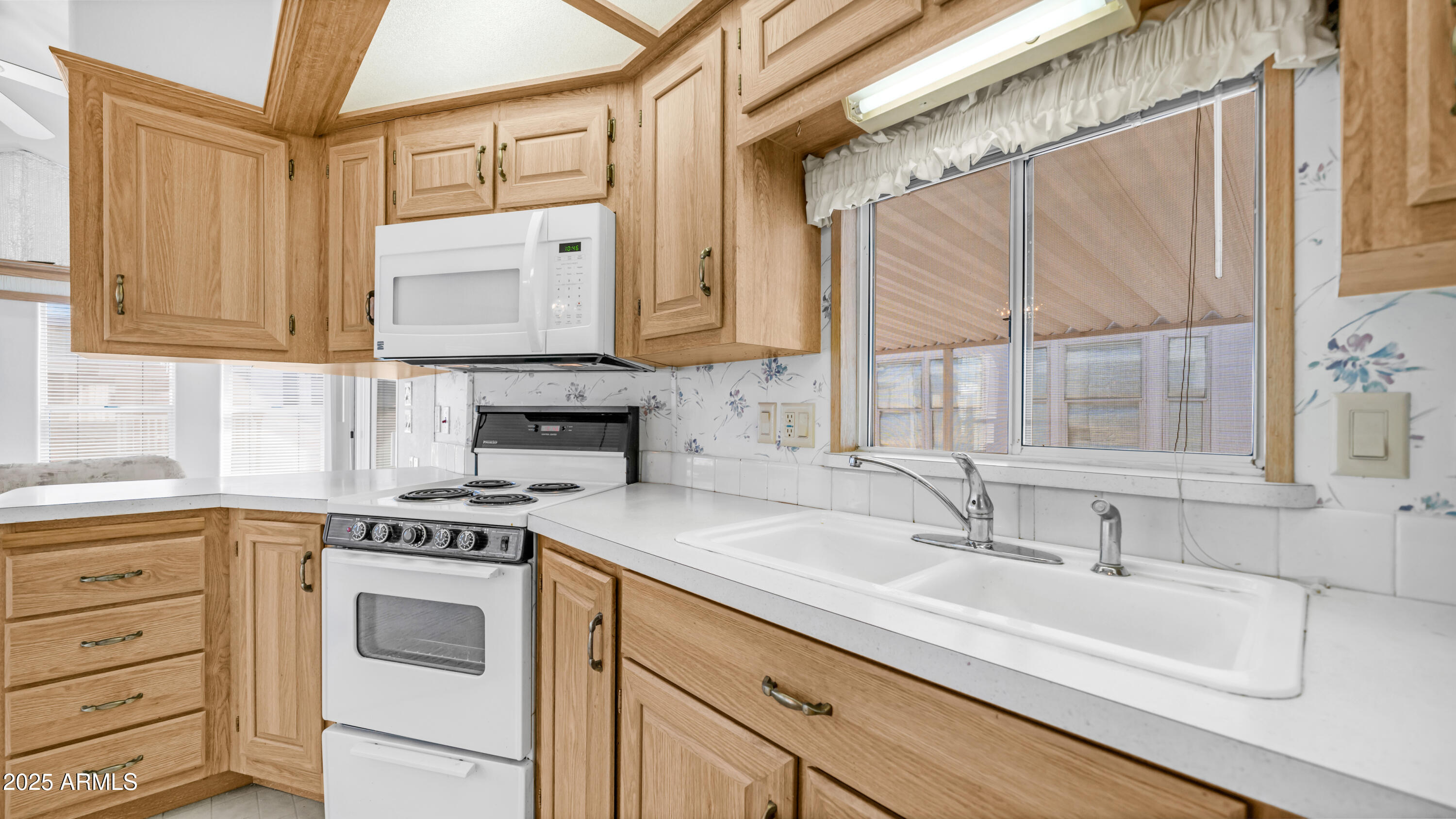 3710 South Goldfield Road, Unit 94 Apache Junction, AZ 85119 - Photo 6 of 48 a kitchen with granite countertop a sink window and cabinets