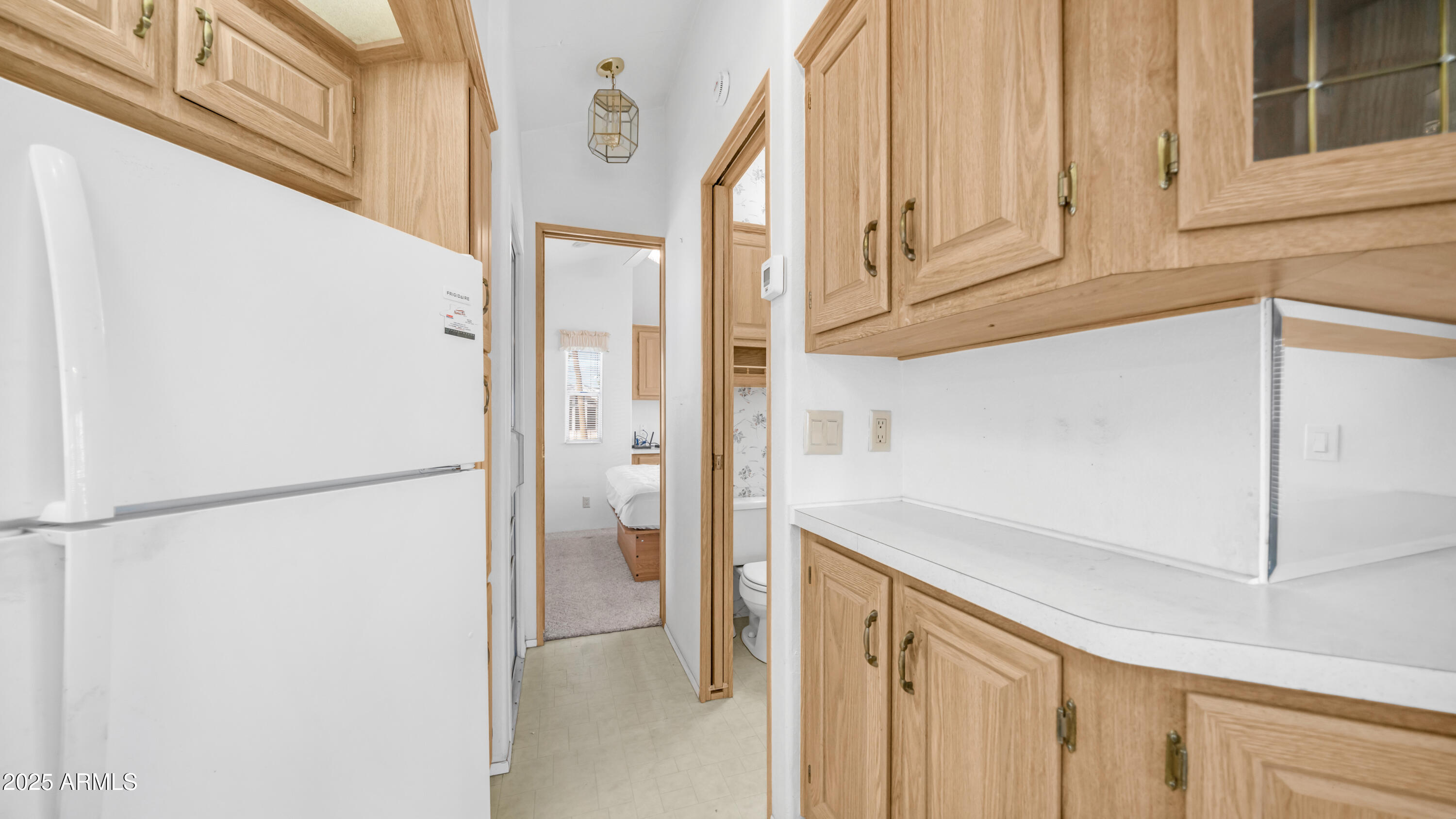 3710 South Goldfield Road, Unit 94 Apache Junction, AZ 85119 - Photo 7 of 48 a view of cabinets and white refrigerator