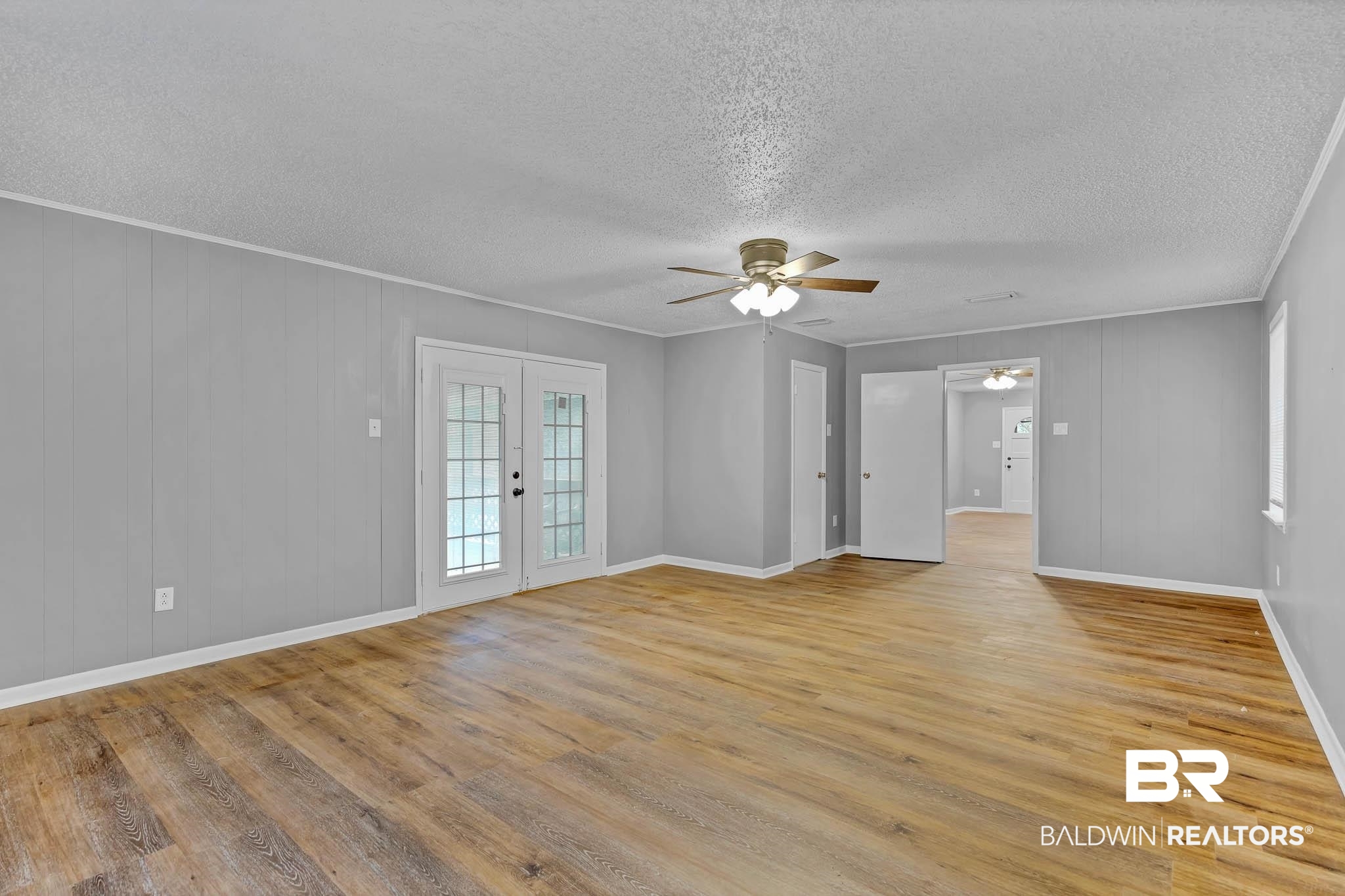 3304 Armond Drive Mobile, AL 36605 - Photo 24 of 62 Spare room featuring a ceiling fan, wood finished floors, a textured ceiling, french doors, and ornamental molding