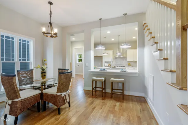 a dining room with wooden floor and a chandelier