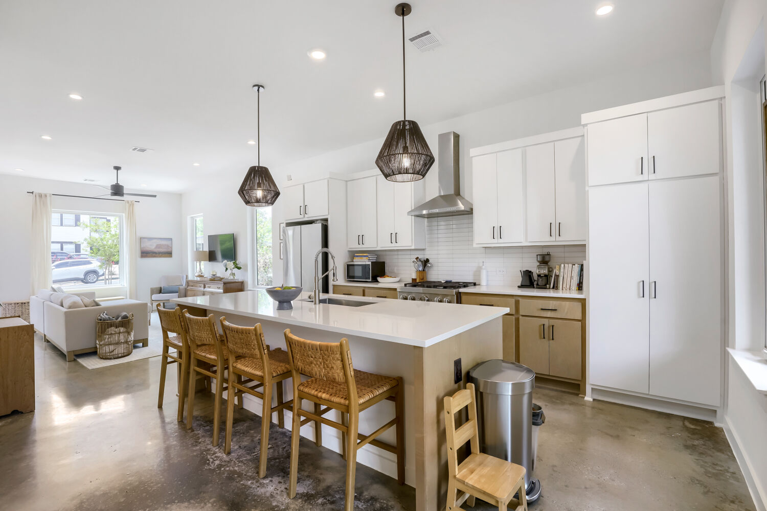 4804 Ribbecke Avenue, Unit A Austin, TX 78721 - Photo 10 of 32 The open-concept living area features a bright kitchen with white cabinetry, stainless steel appliances, and a central island with bar seating