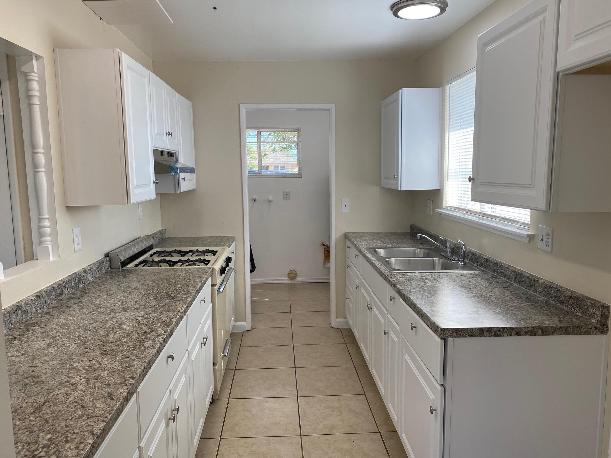 45325 Raysack Avenue Lancaster, CA 93535 - Photo 5 of 17 a kitchen with a granite countertop sink stove and cabinets