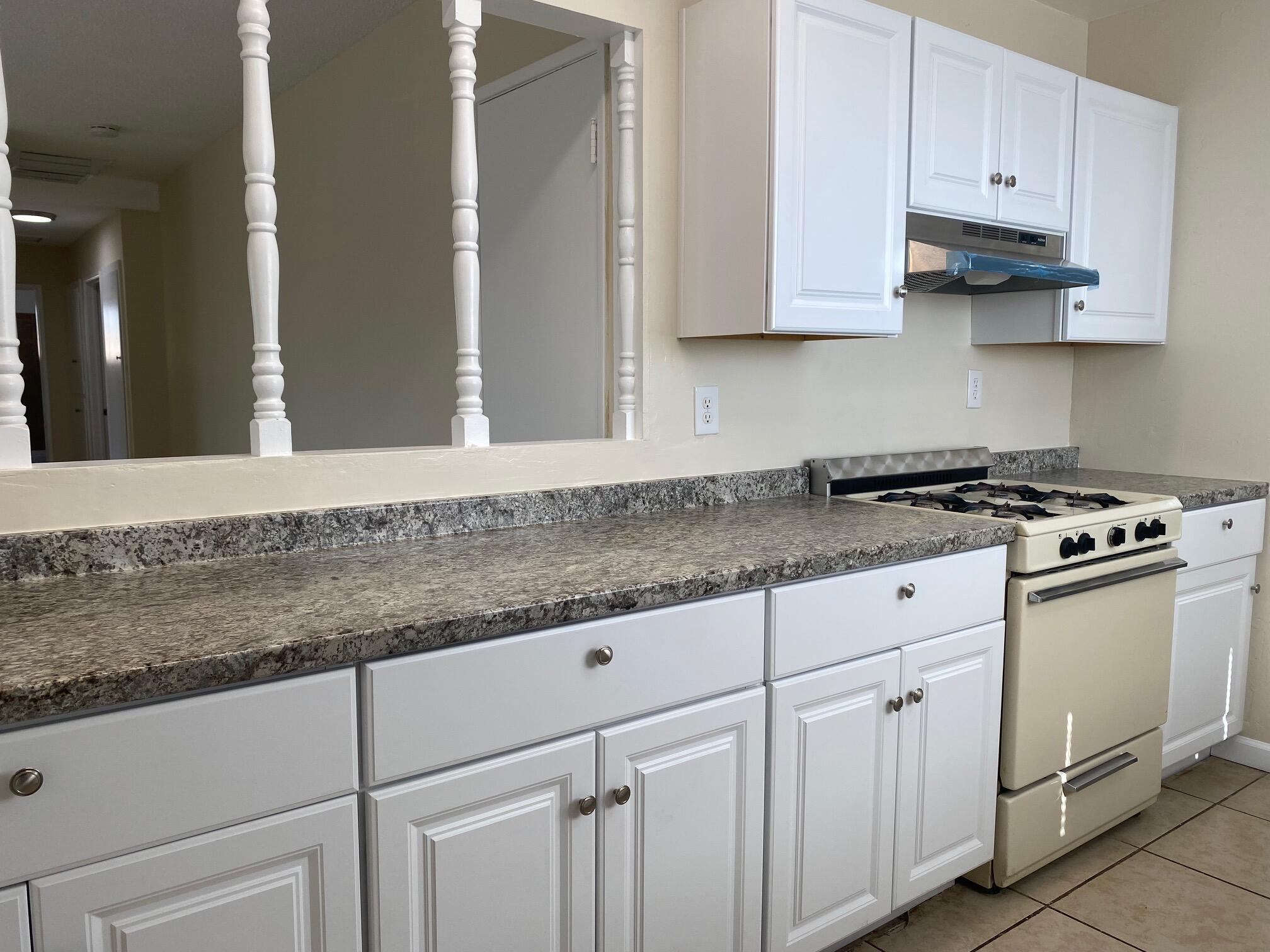 45325 Raysack Avenue Lancaster, CA 93535 - Photo 6 of 17 a kitchen with granite countertop white cabinets and white appliances