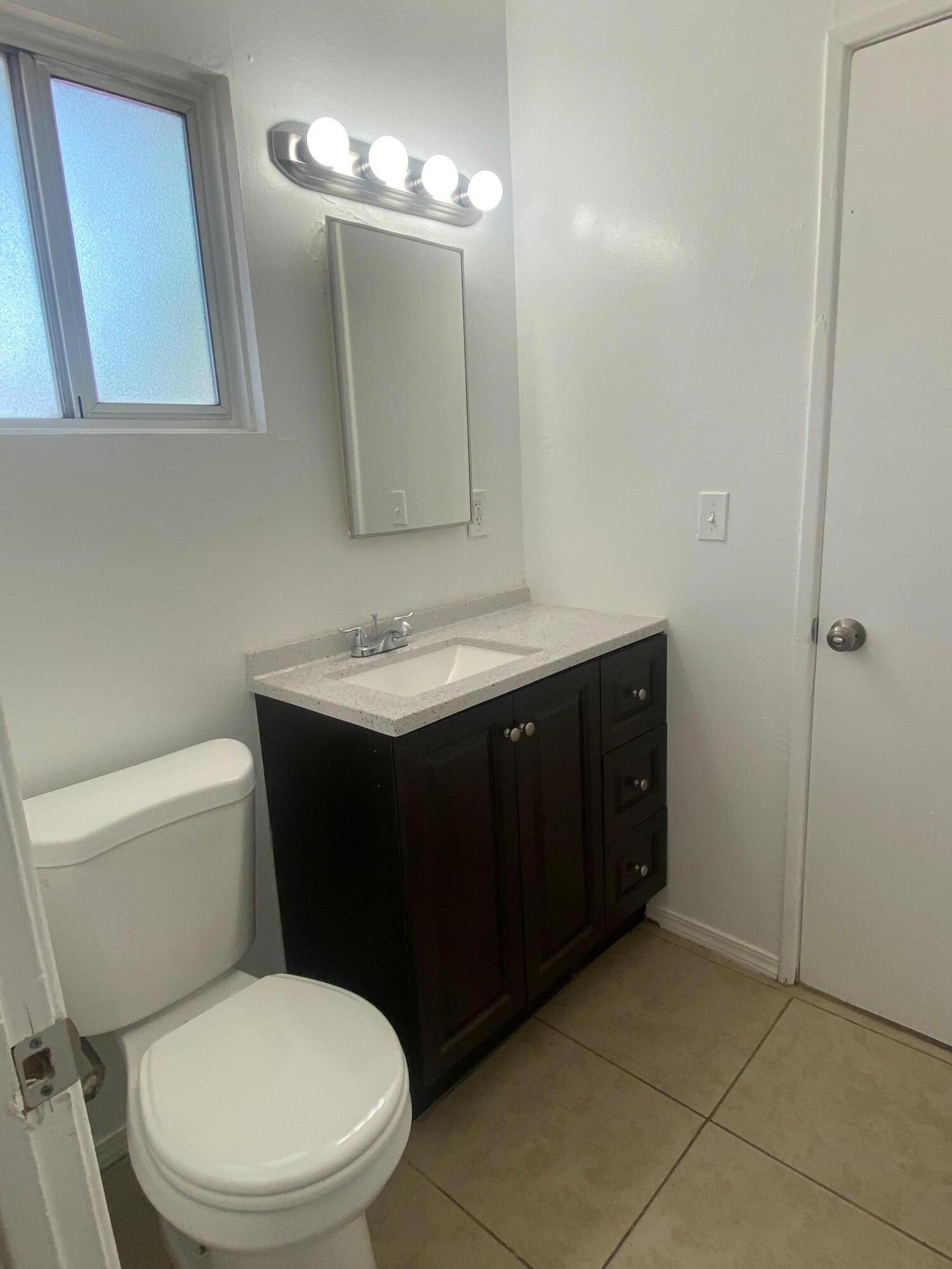 45325 Raysack Avenue Lancaster, CA 93535 - Photo 9 of 17 a bathroom with a toilet sink vanity granite and mirror