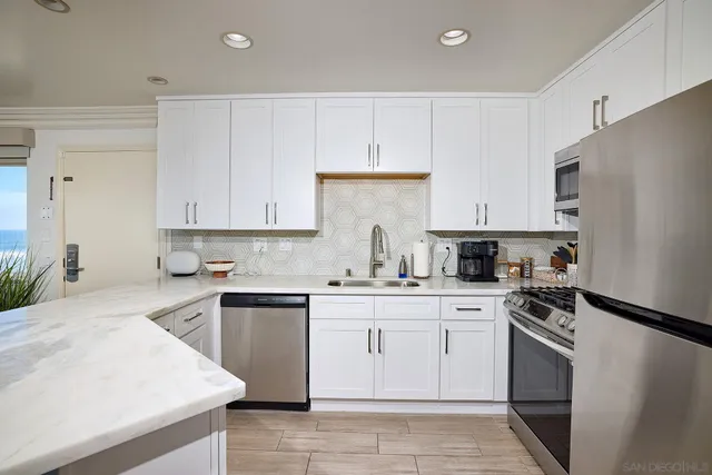 a kitchen with cabinets appliances a sink and a counter top space