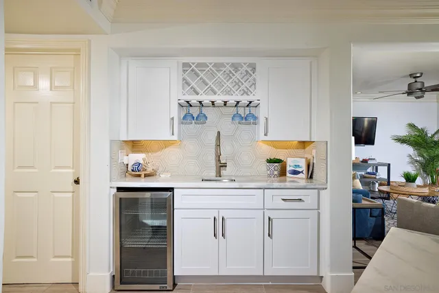 a kitchen with white cabinets and sink