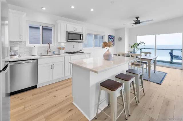 a kitchen with granite countertop white cabinets and stainless steel appliances