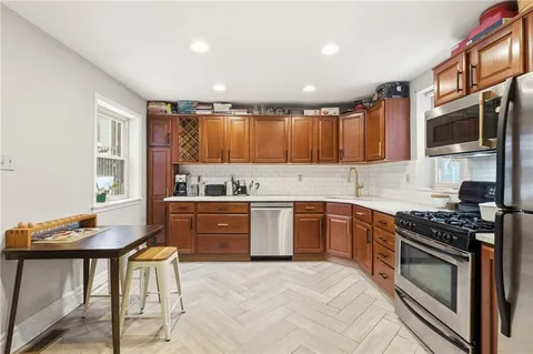 a kitchen with stainless steel appliances granite countertop a stove a sink dishwasher and cabinets with wooden floor