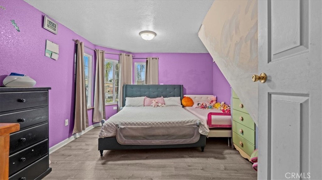 742 South Magnolia Avenue Rialto, CA 92376 - Photo 8 of 19 a bedroom with a bed and wooden floor
