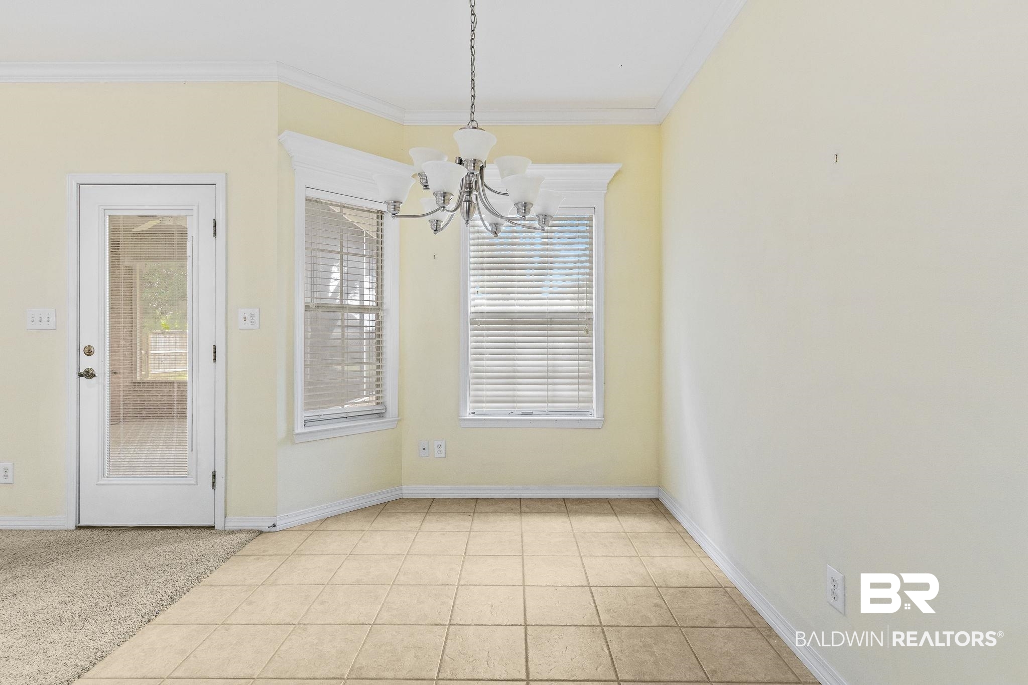 166 Club Drive Fairhope, AL 36532 - Photo 18 of 41 Unfurnished dining area with crown molding, a chandelier, and light tile patterned flooring