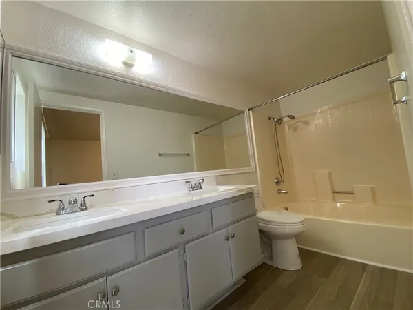a spacious bathroom with a double vanity sink a toilet and shower