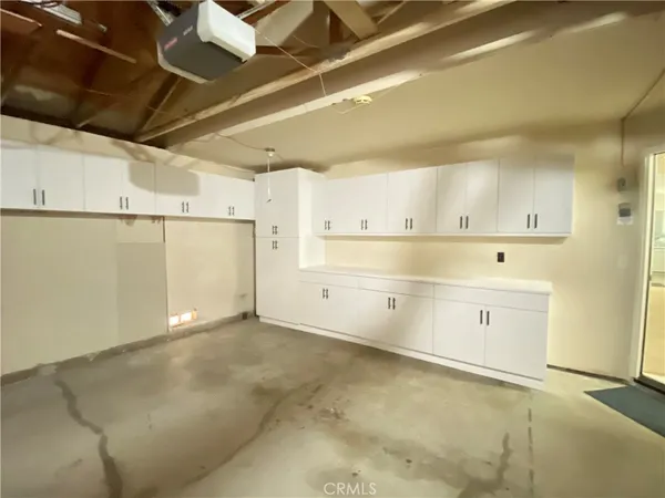 a view of a kitchen with white cabinets and wooden floor