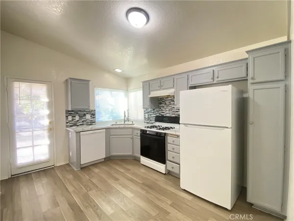 a kitchen with a refrigerator sink stove and cabinets