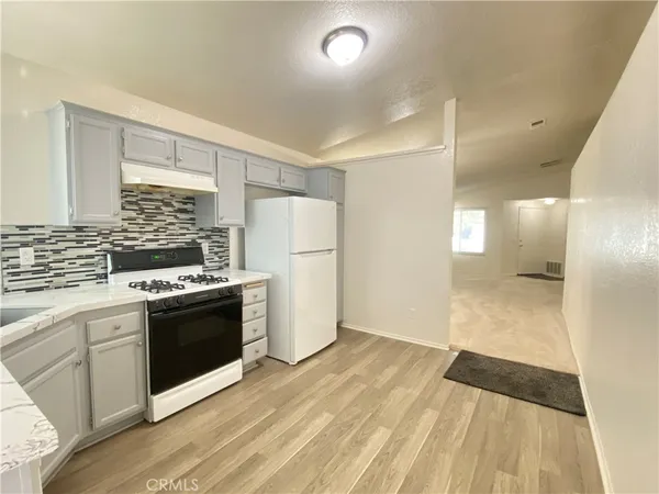 a kitchen with a refrigerator and a stove top oven