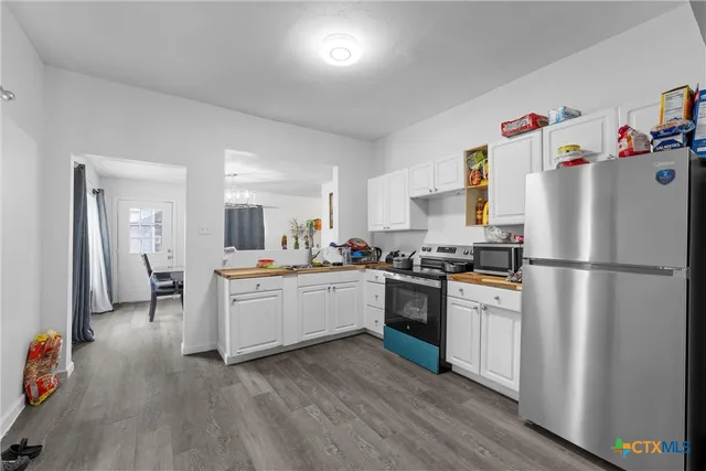 a kitchen with white cabinets and white appliances