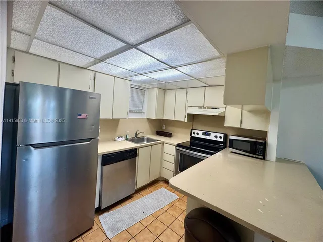 a kitchen with a refrigerator and a stove top oven