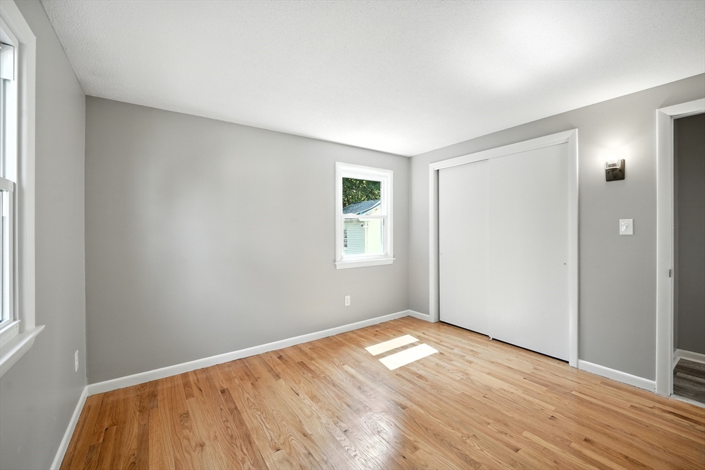 55 Governor Street Springfield, MA 01104 - Photo 14 of 28 an empty room with wooden floor and windows